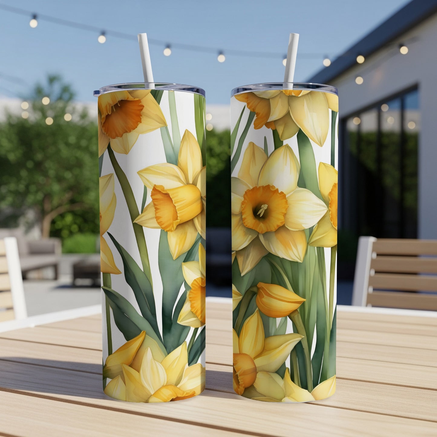 Two tumblers with a yellow daffodil floral pattern, resting on a wooden table.
