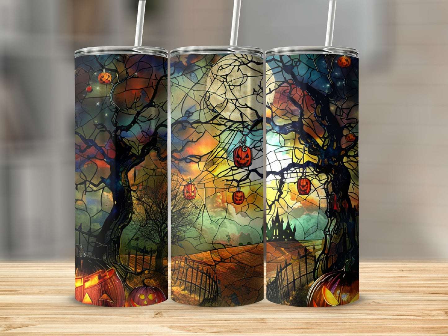Halloween themed tumblers with pumpkins and spooky trees.
