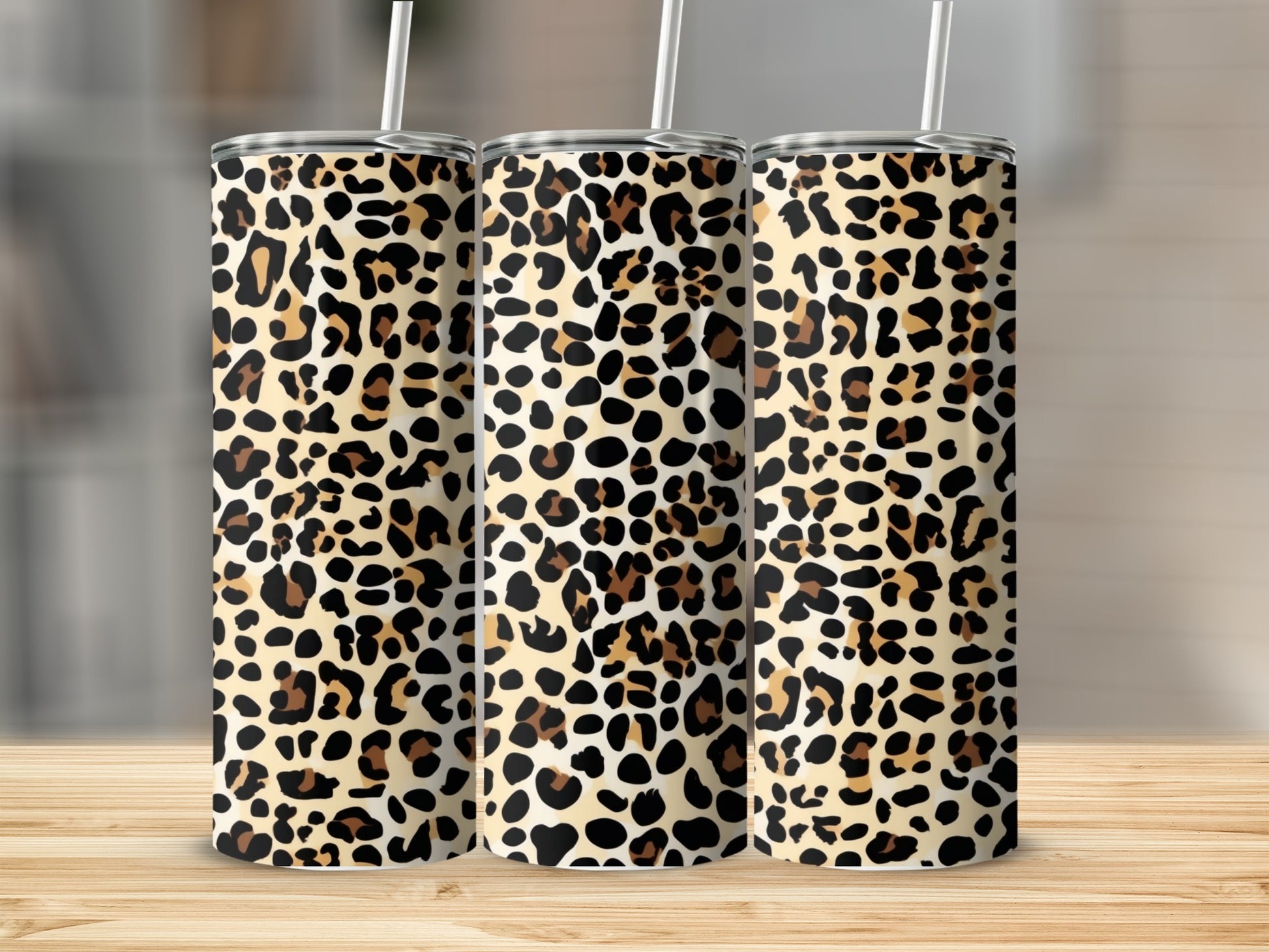 Three tumblers with leopard print and white straws.
