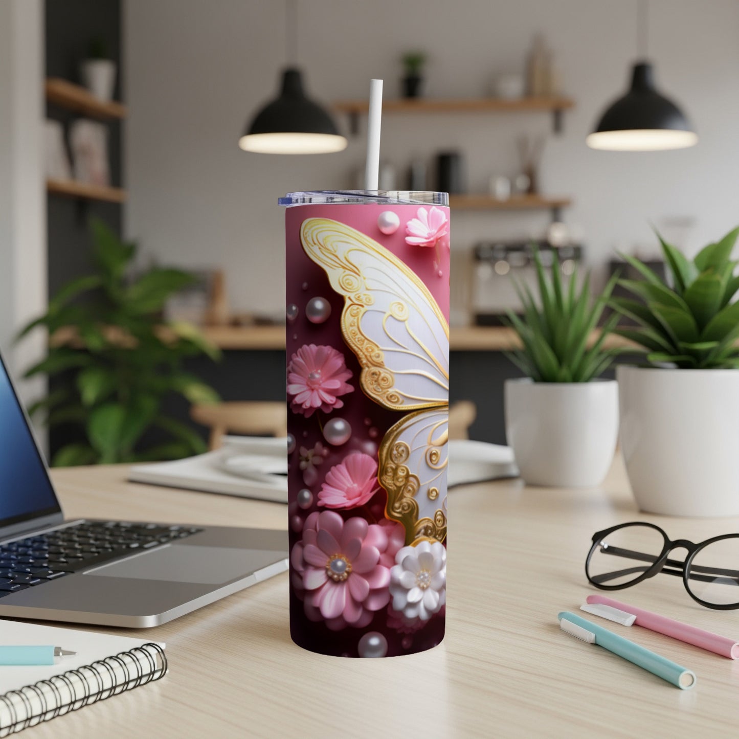 Pink floral butterfly tumbler with straw on desk.