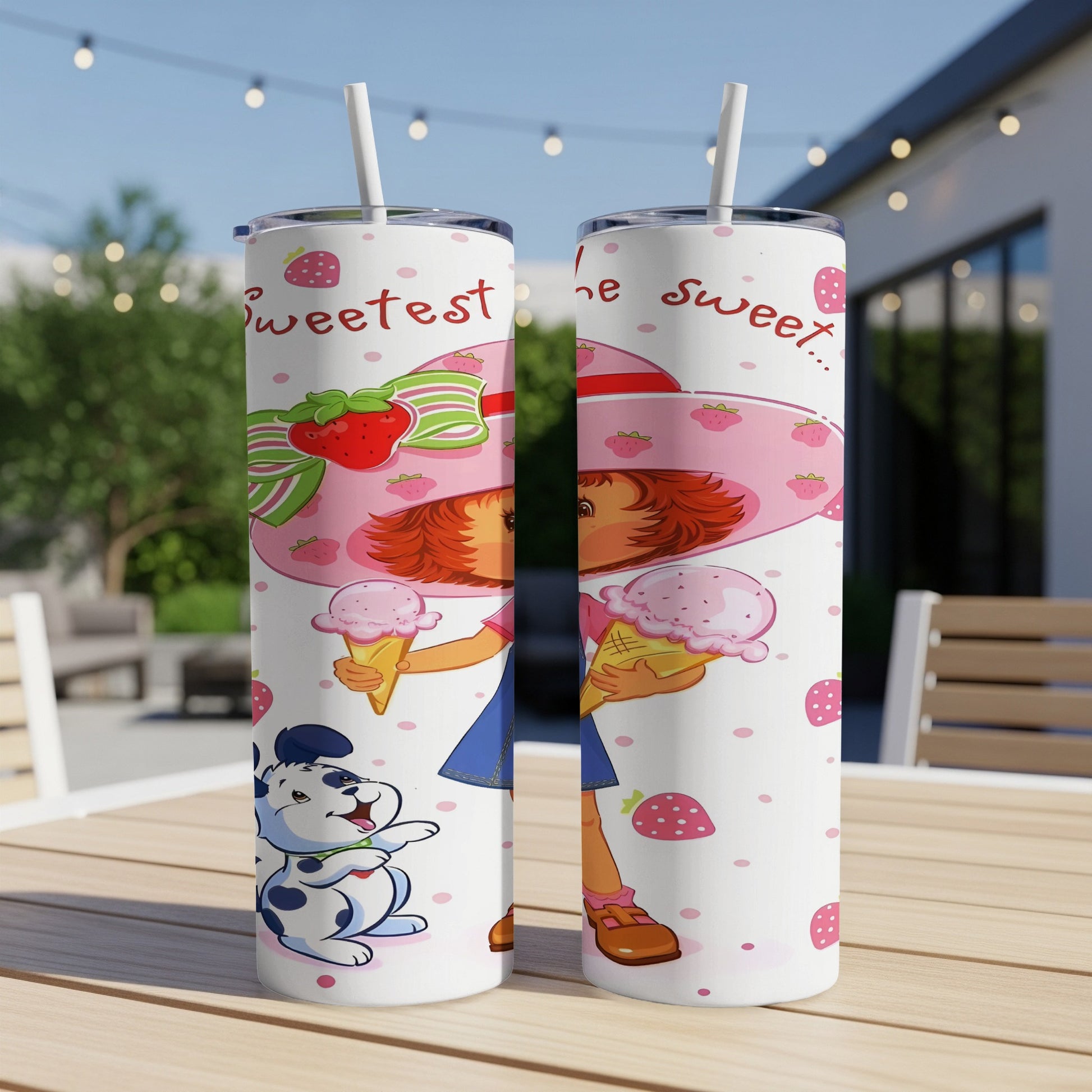 Strawberry Shortcake holding ice cream with cartoon dog on a pink patterned tumbler.