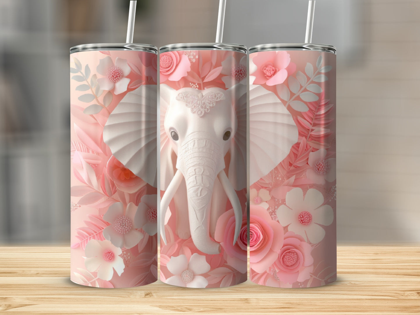 Three pink floral tumblers featuring a white elephant head on a wood background.