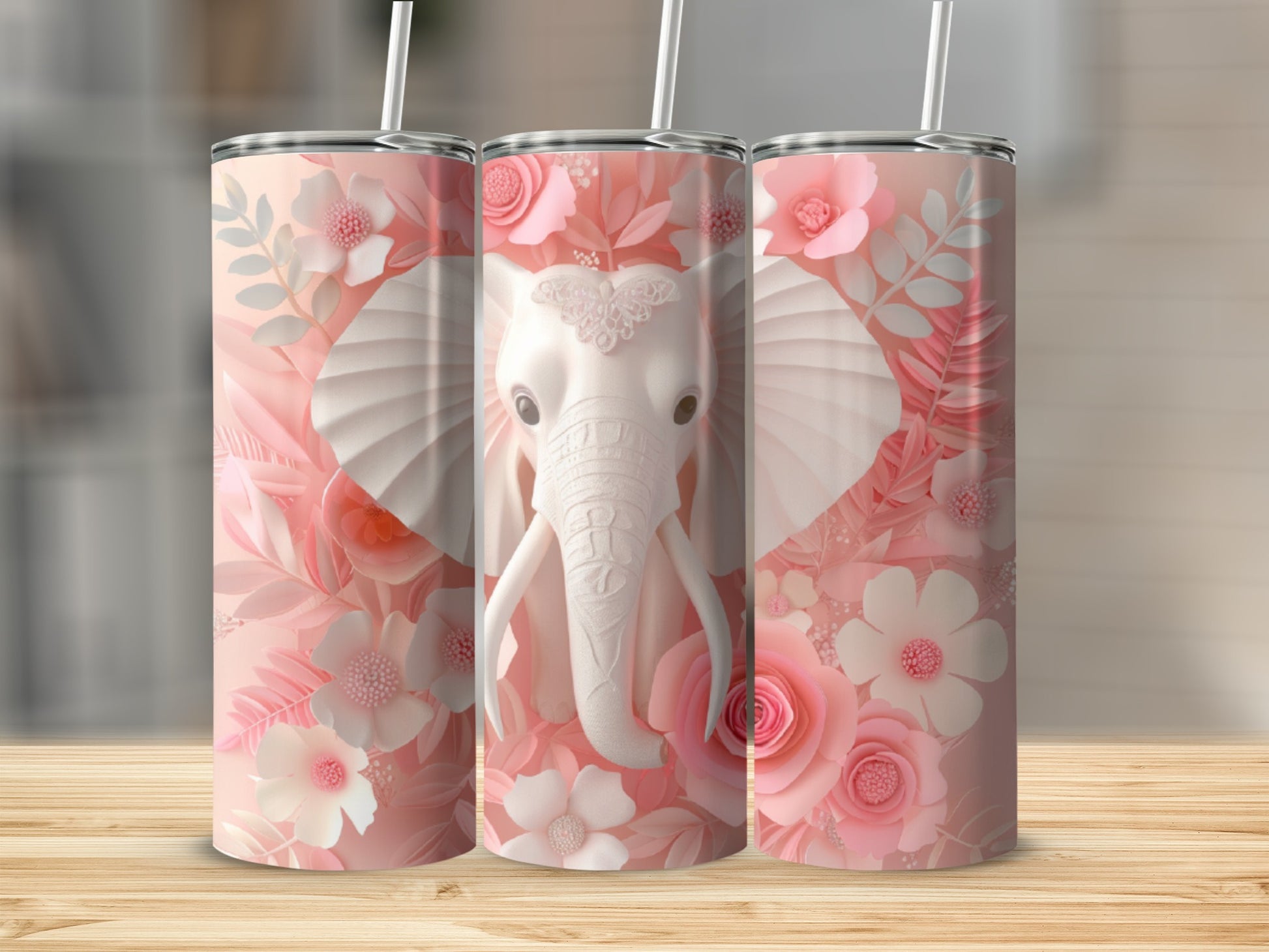 Three pink floral tumblers featuring a white elephant head on a wood background.