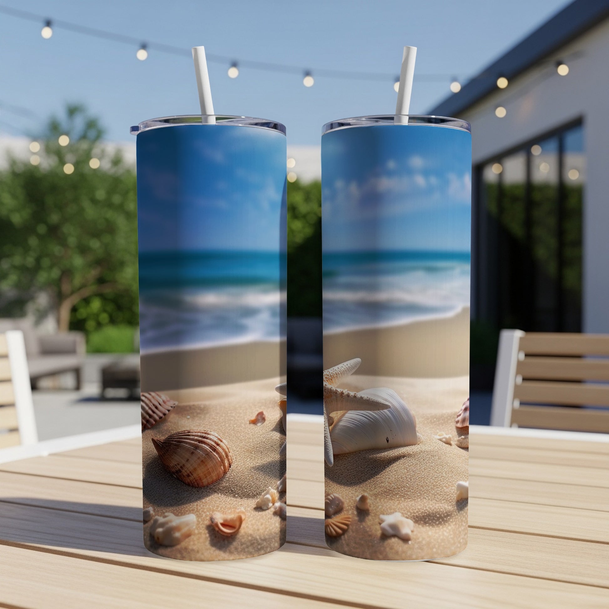 Two beach-themed tumblers with seashells and sand on a patio table.