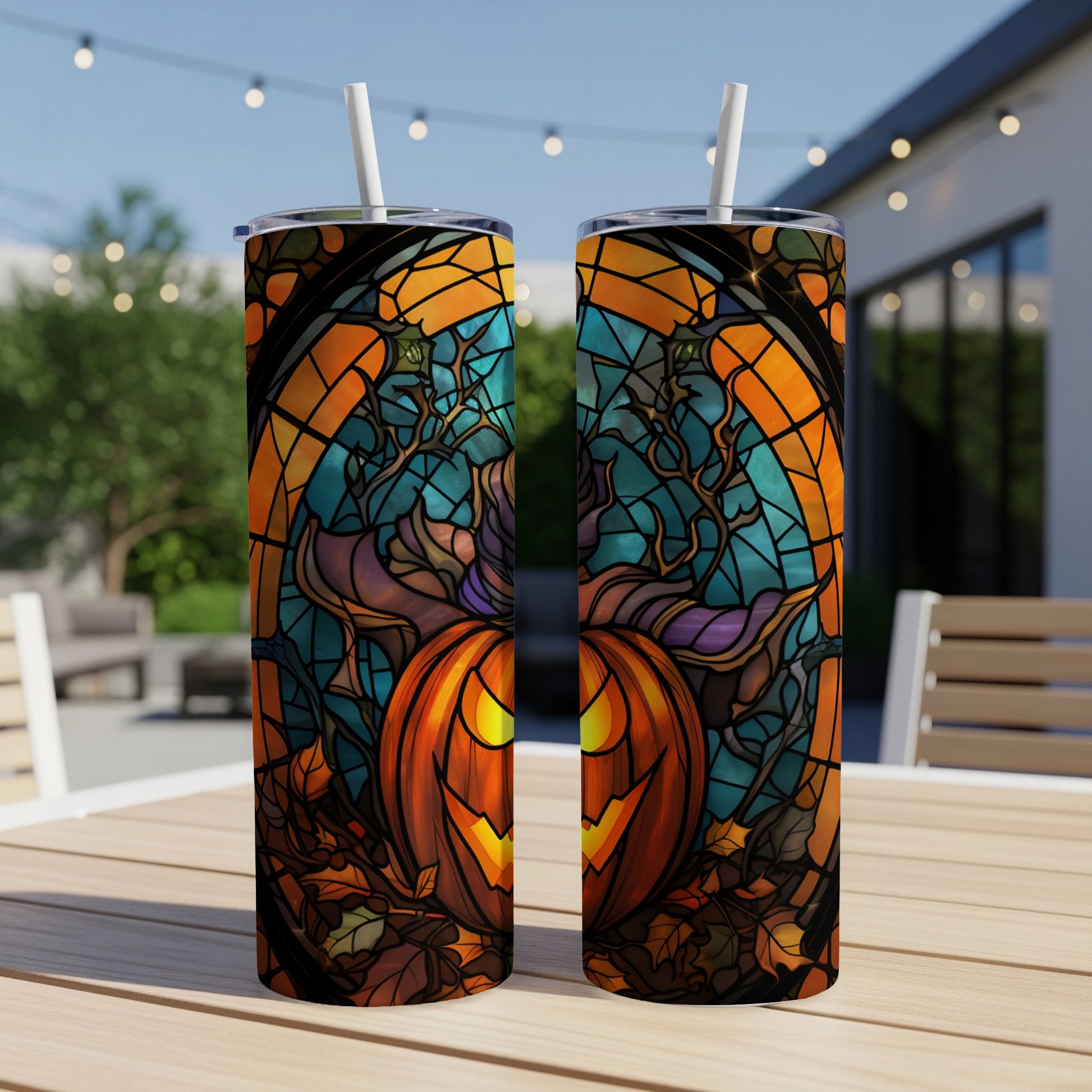 Two tumblers with a jack-o'-lantern stained-glass design, resting on a table.