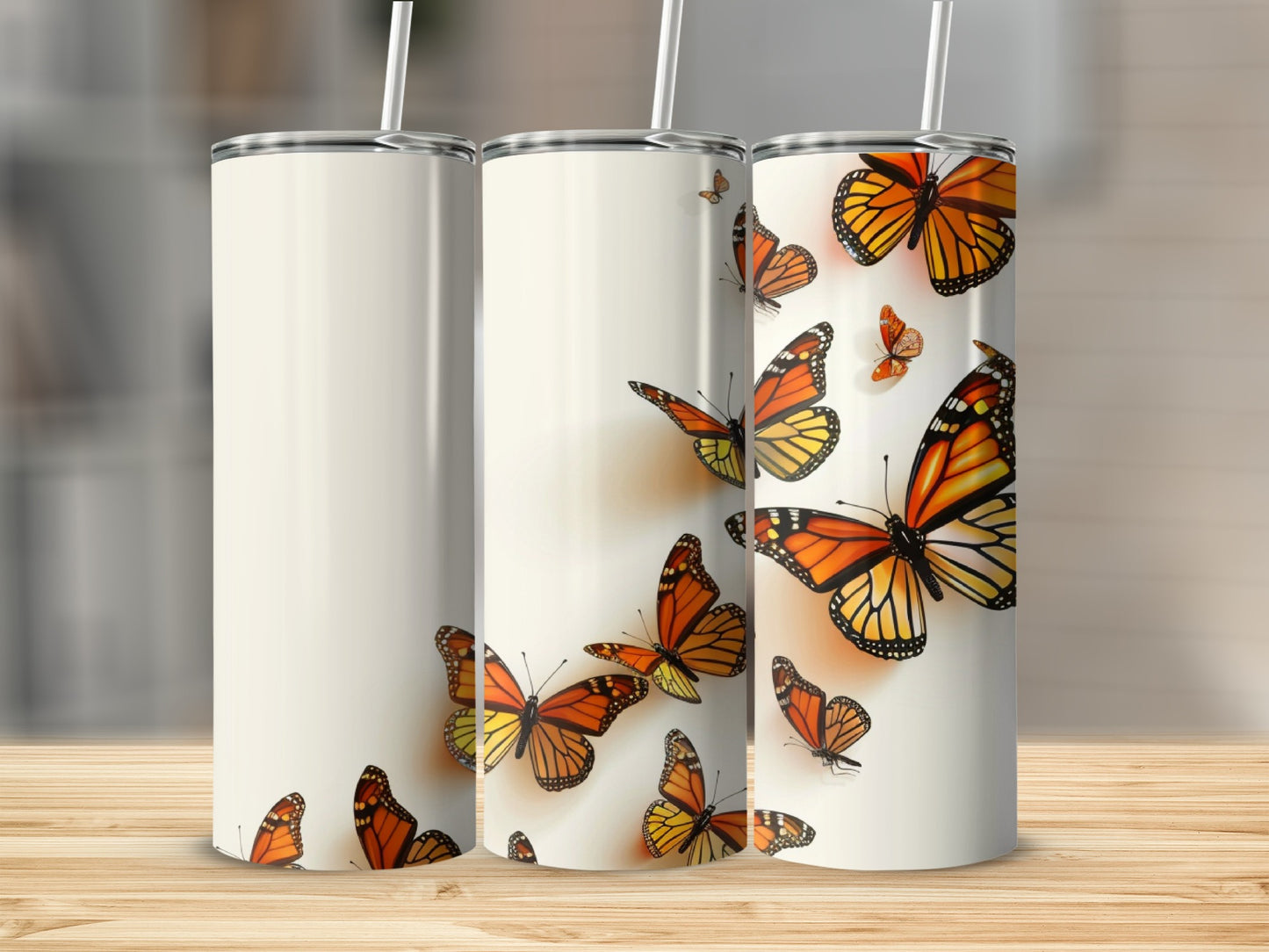 Three tumblers with monarch butterflies in varying sizes and positions.