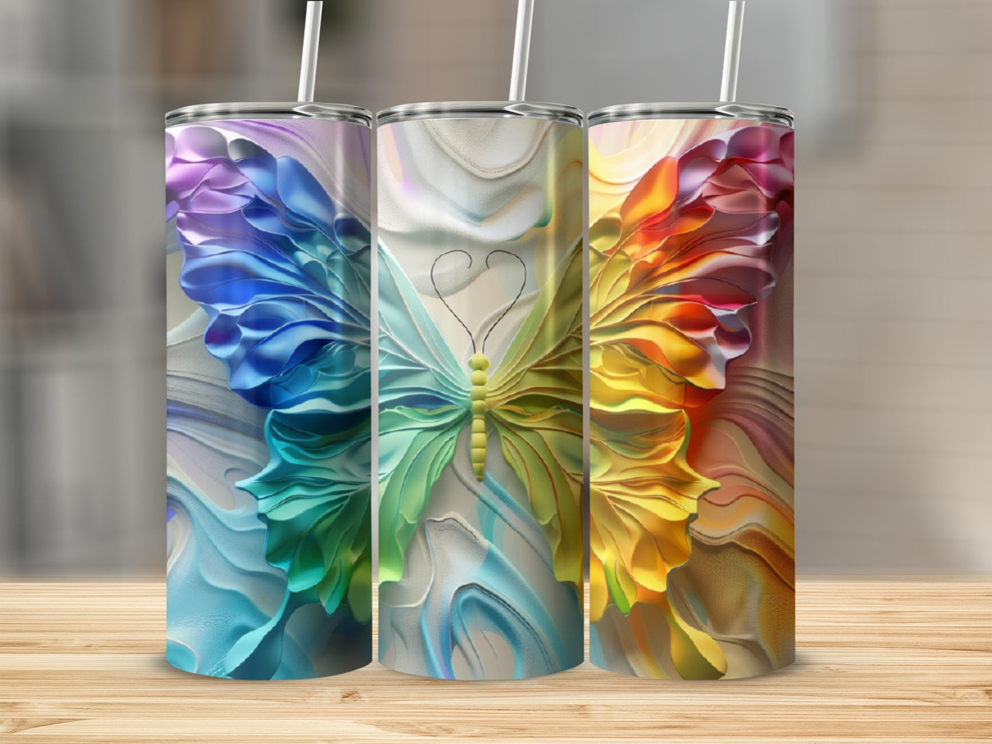 Three tumblers with butterfly designs and colorful, textured patterns.