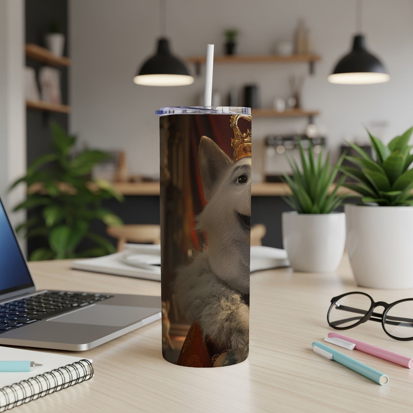 White dog wearing a crown on a tall tumbler on a desk.