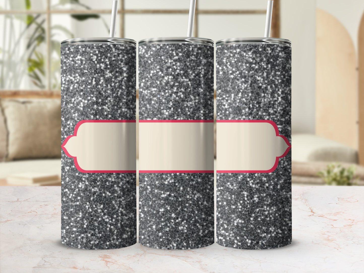 Three glitter tumblers with blank cream labels on a marble surface.