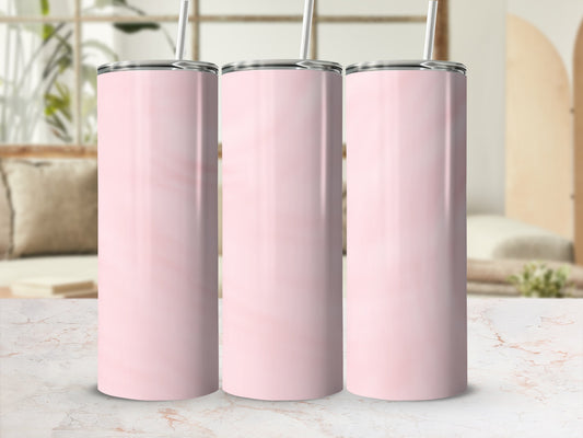Three pink marbled tumblers with straws on a marble surface.