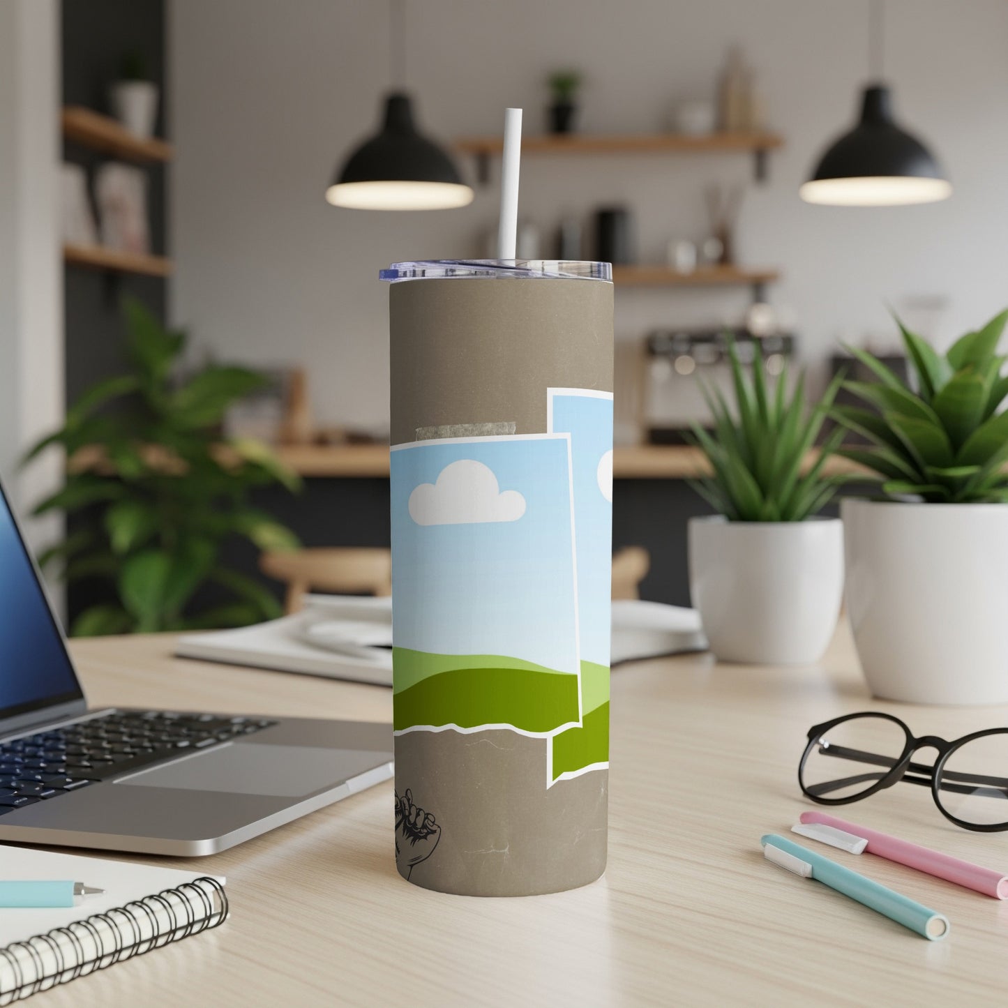 Tan tumbler with illustrated clouds, hills, and a raised fist.