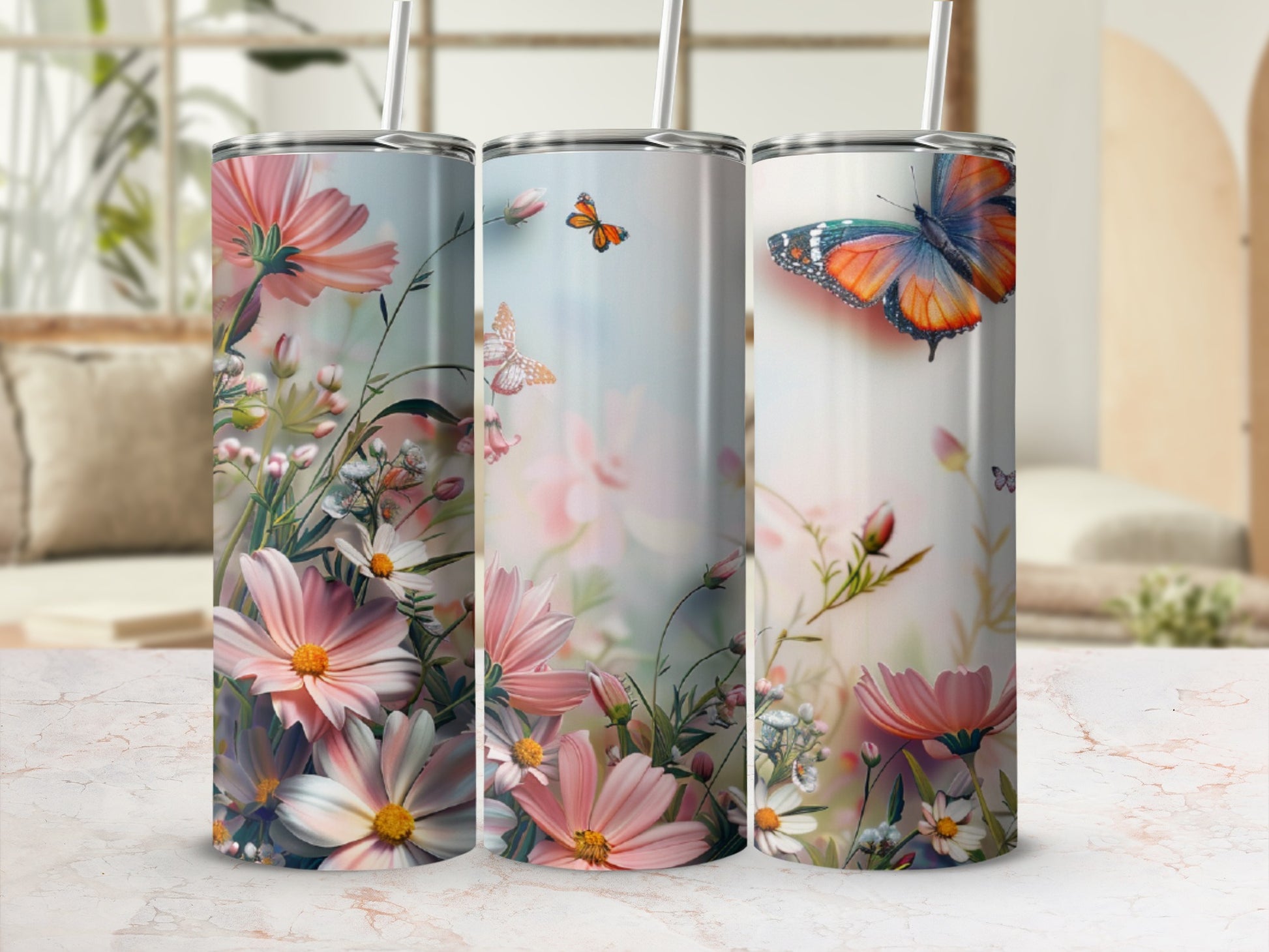 Three tumblers with floral and butterfly designs on a white background.