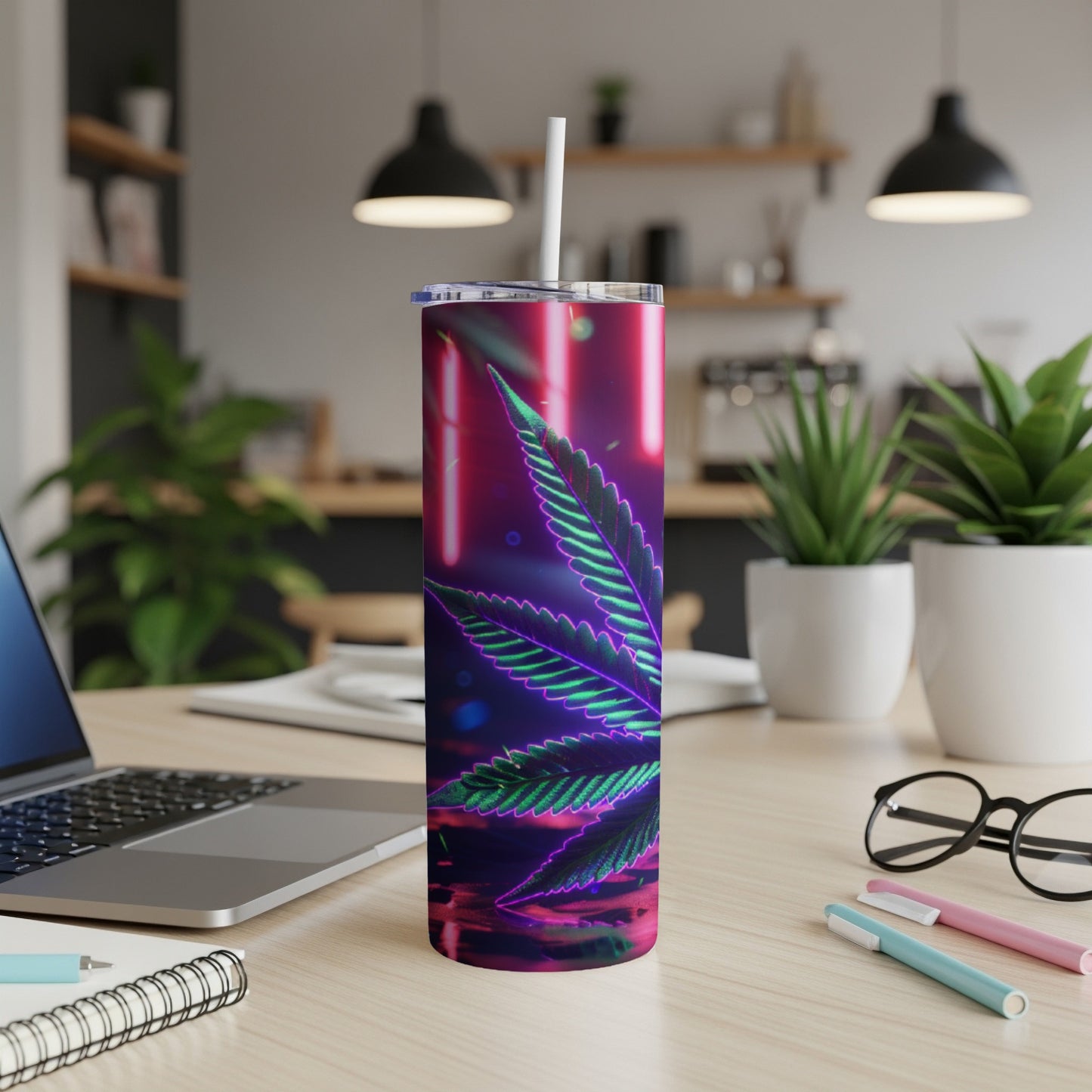 Tumbler with a neon cannabis leaf design on a desk.