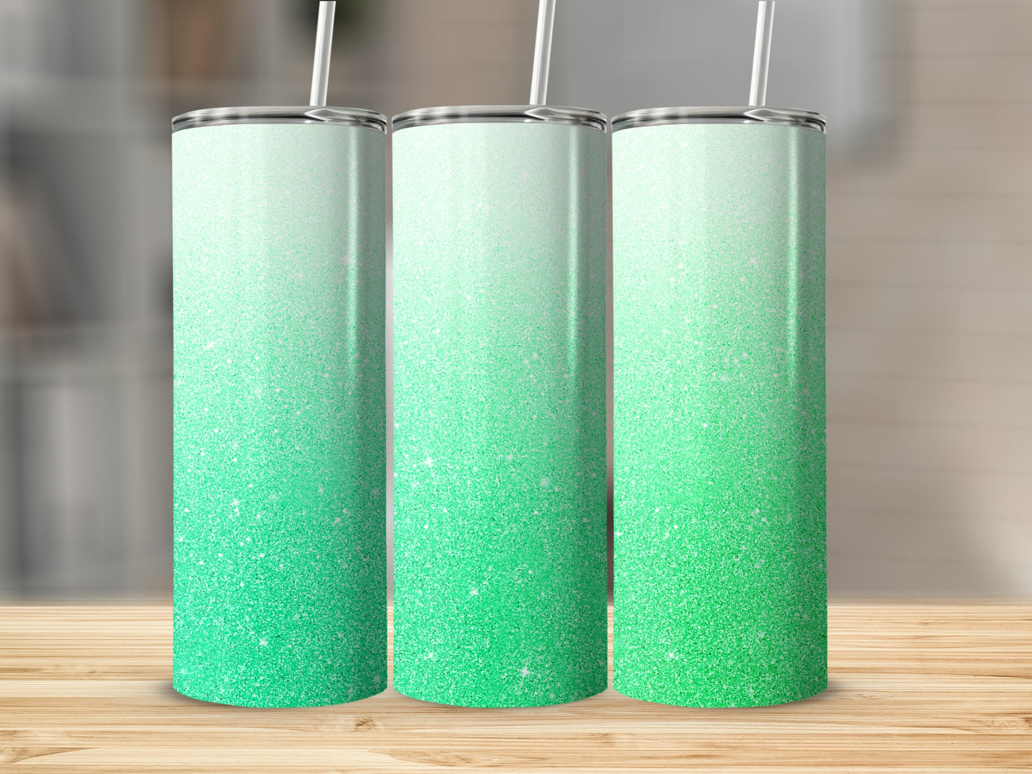 Three glitter tumblers with ombre green to white gradient and straws.