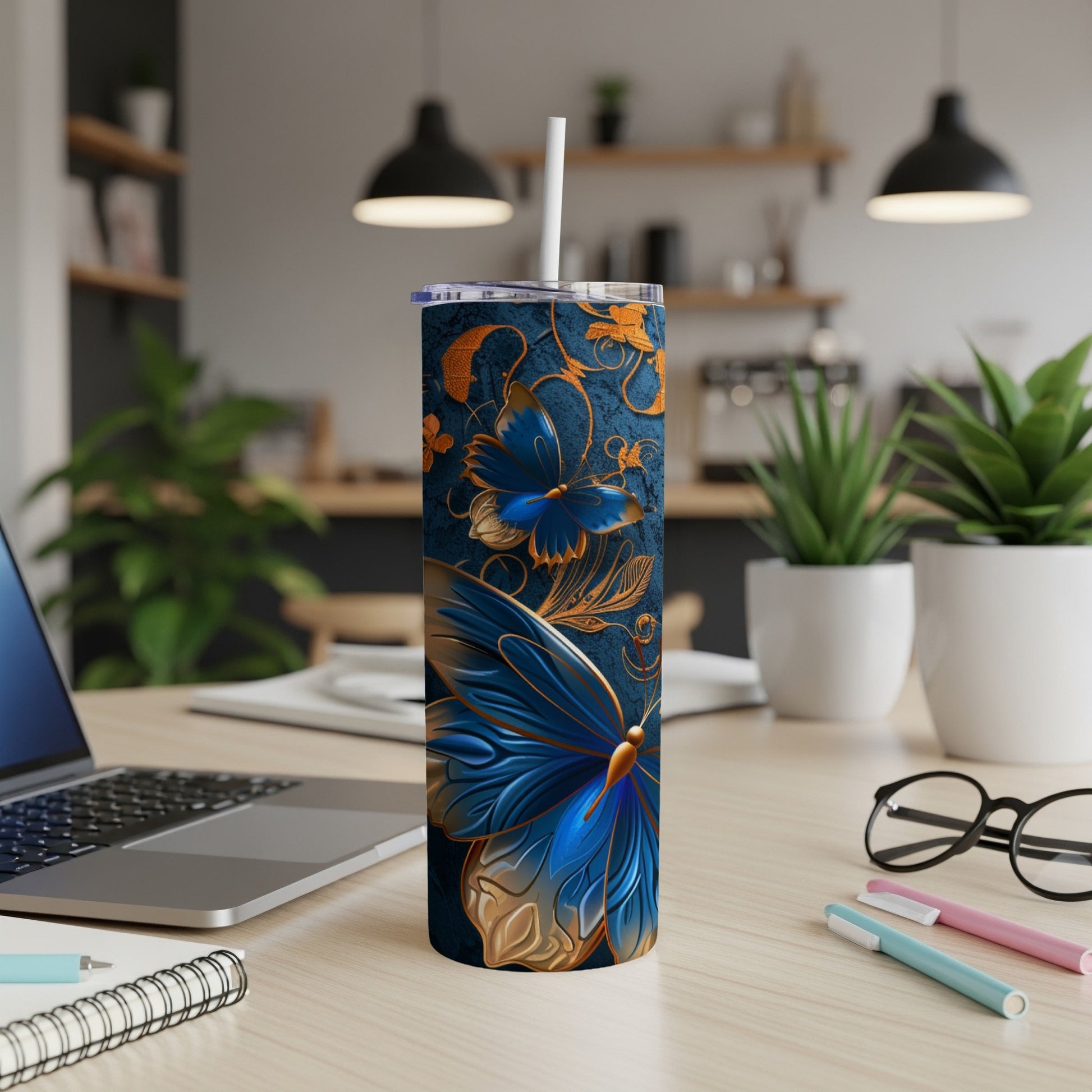 Blue and gold butterfly design on a white tumbler with straw.