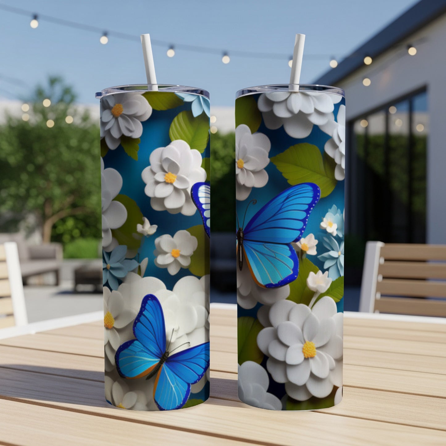 Two tumblers with blue butterflies and white flowers on a wooden table.
