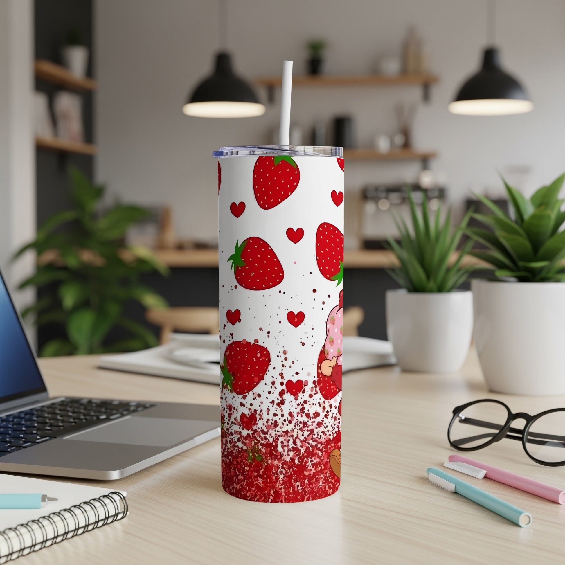 White tumbler with strawberries and a gnome design, on a desk.