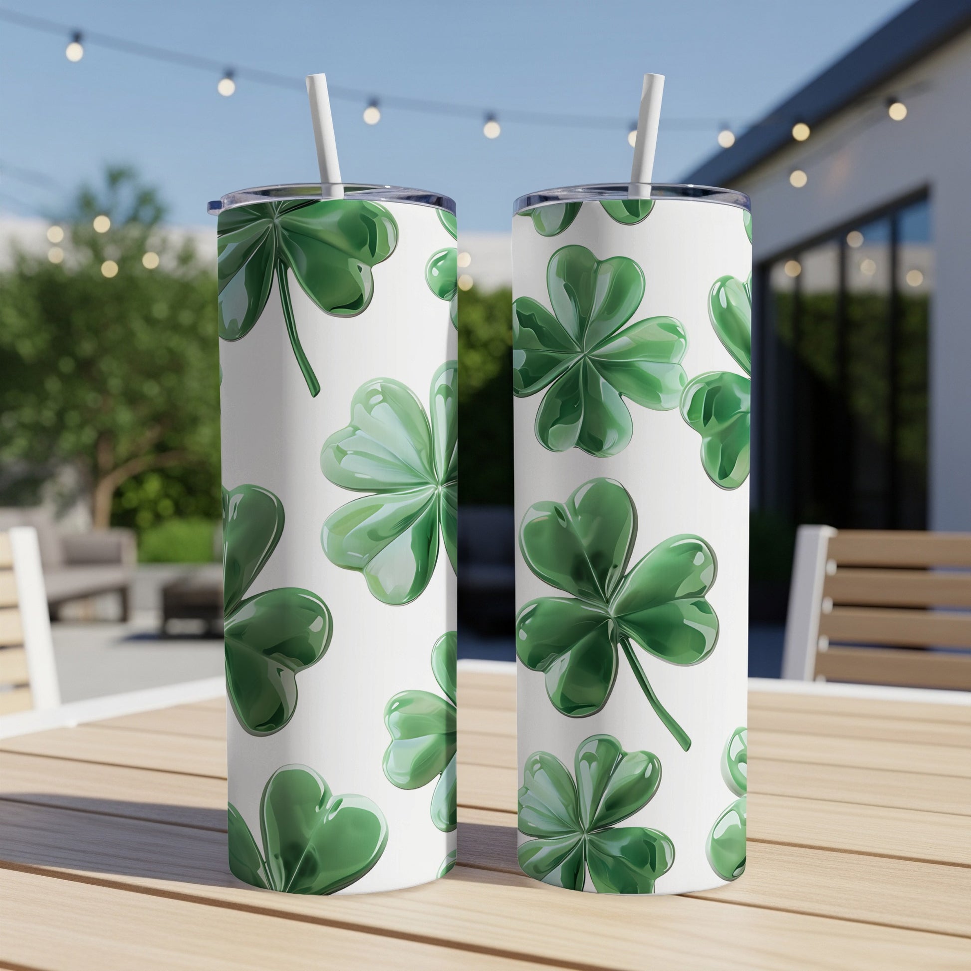 Two white tumblers with a shamrock pattern and straws.