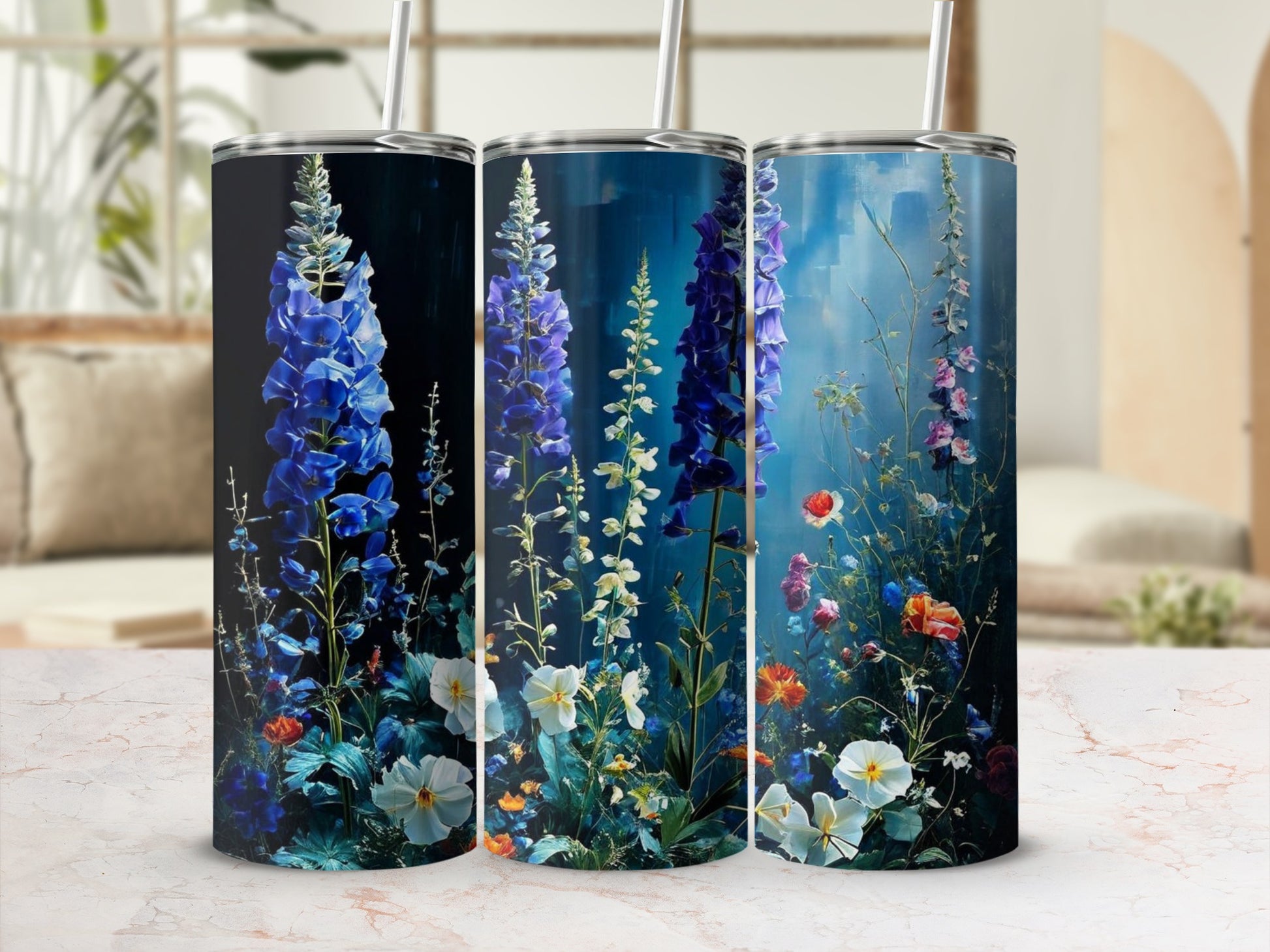 Three tumblers with floral designs, featuring blue delphiniums and colorful wildflowers.