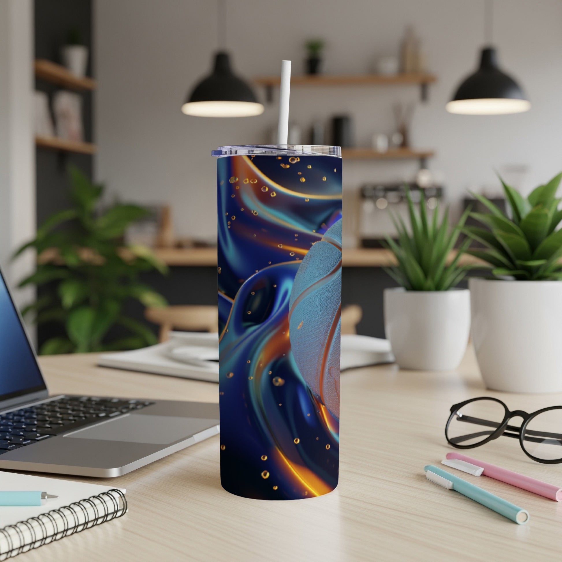 Blue and orange abstract design tumbler with straw on desk.