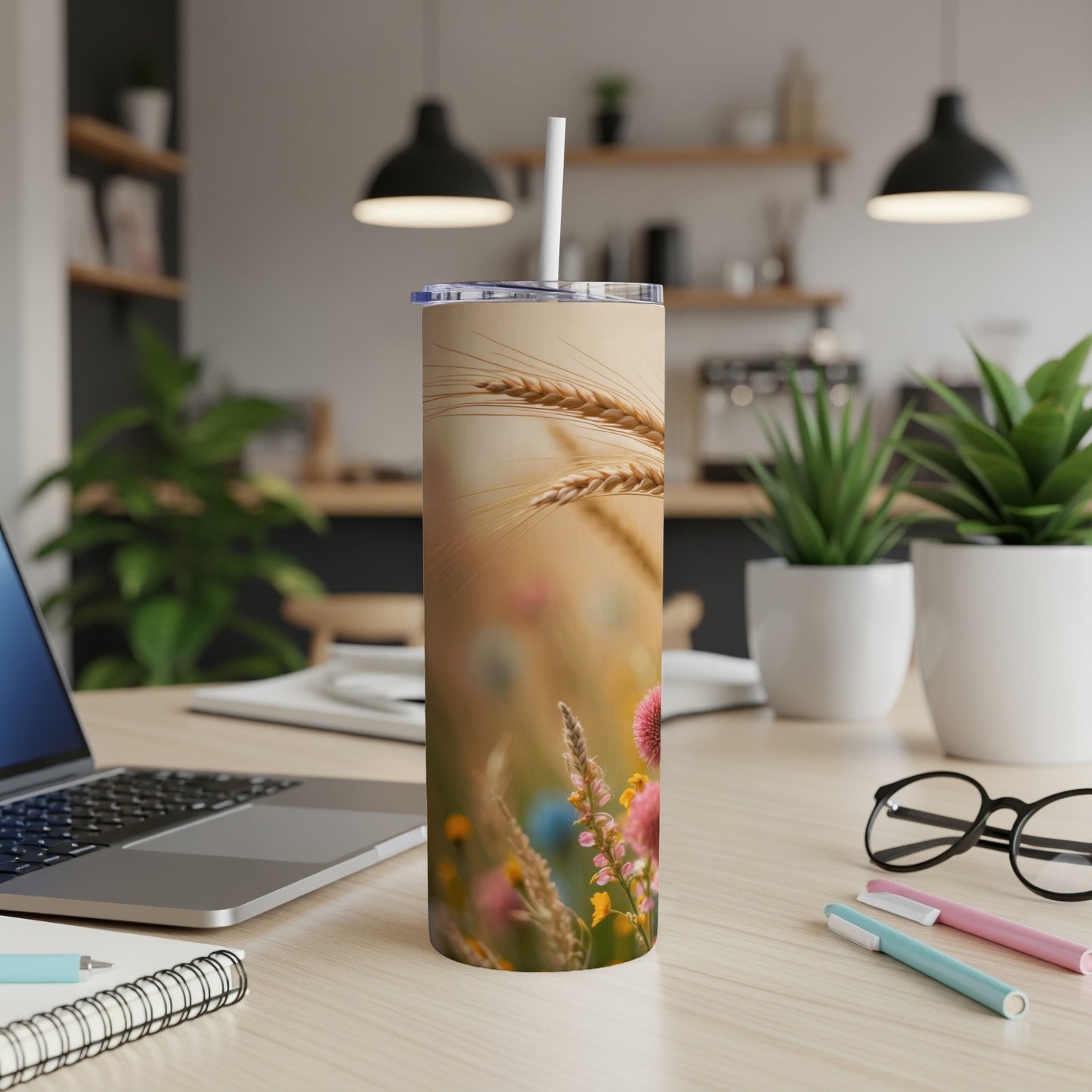 Wheat stalks and wildflowers wrap around a white tumbler with a straw.