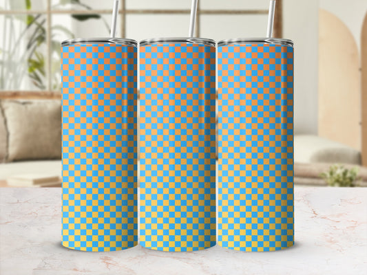 Three blue and orange checkered tumblers with straws on a marble surface.