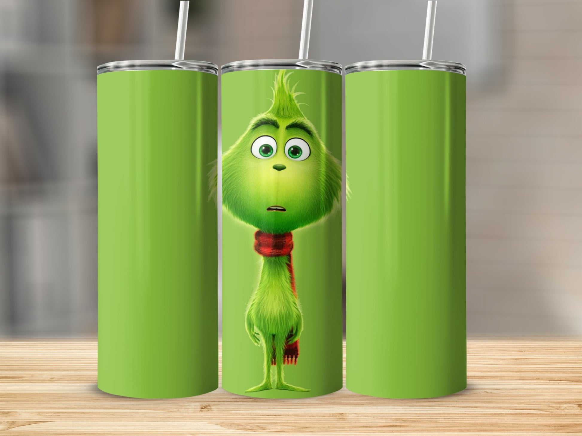 The Grinch wearing a red scarf on a green tumbler.