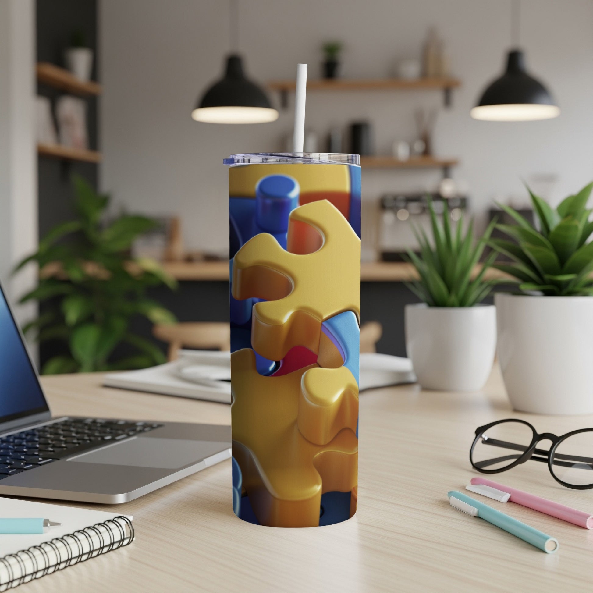 Yellow and blue puzzle pieces on a white tumbler with a straw.