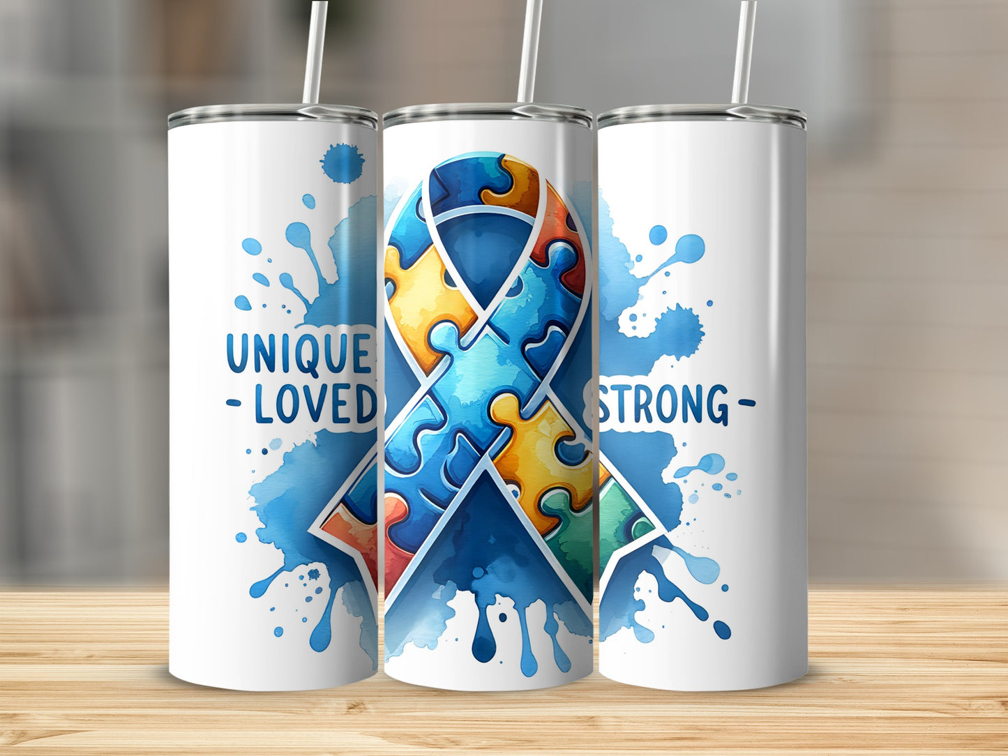 White tumblers with blue watercolor puzzle ribbon and text "UNIQUE - LOVED - STRONG".