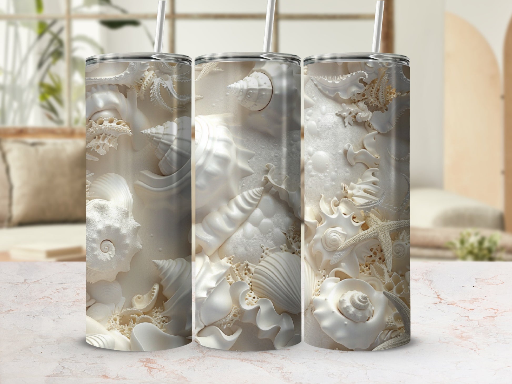 White seashells and starfish embossed on three tall tumblers with straws.