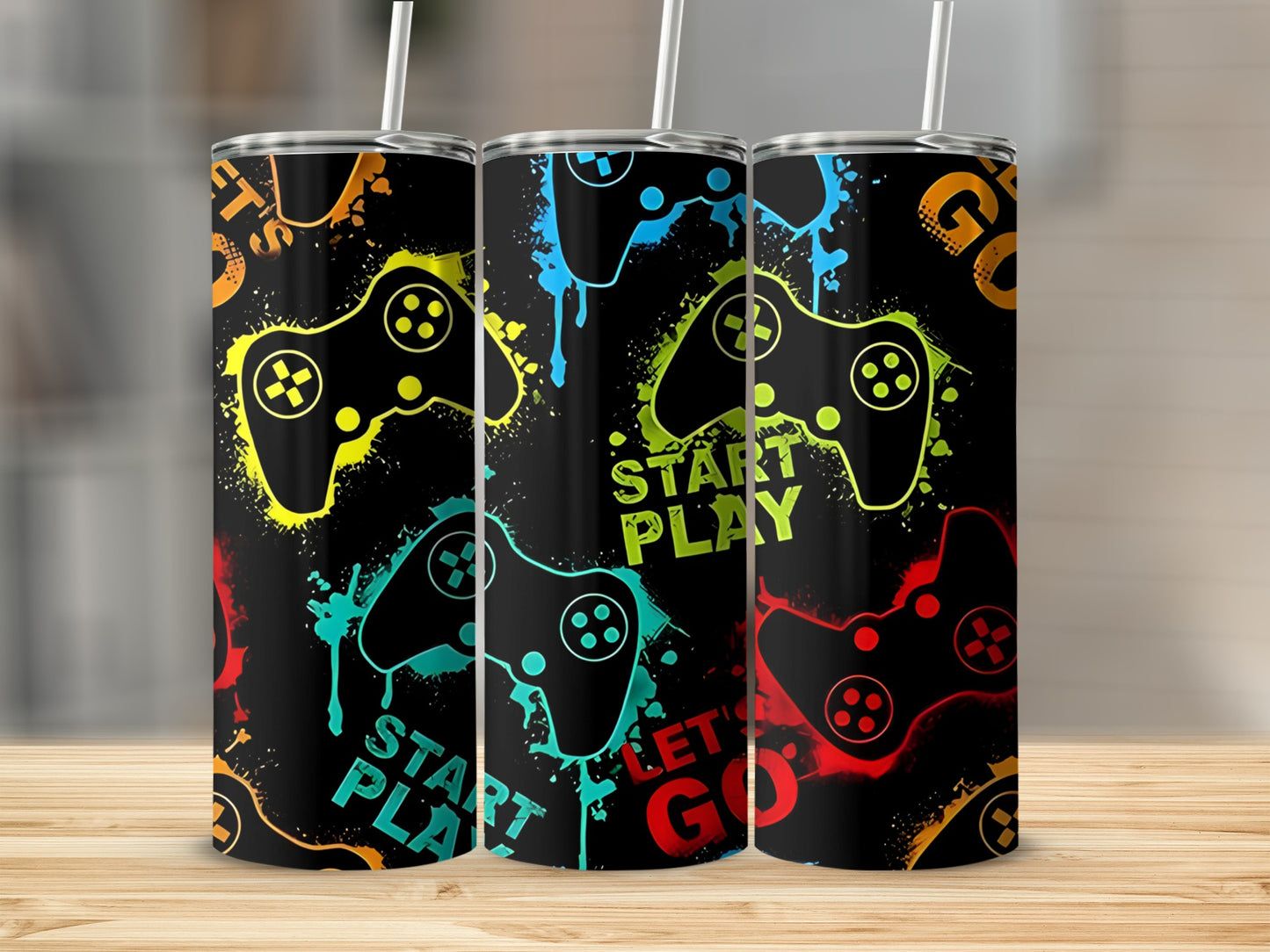 Three tumblers with a black background, colorful game controller designs, and text.