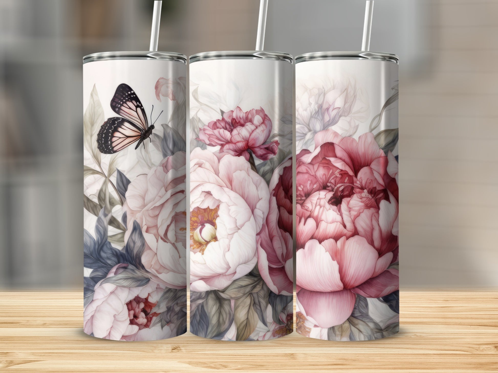 Three tumblers with peony floral and butterfly designs stand on a wooden surface.