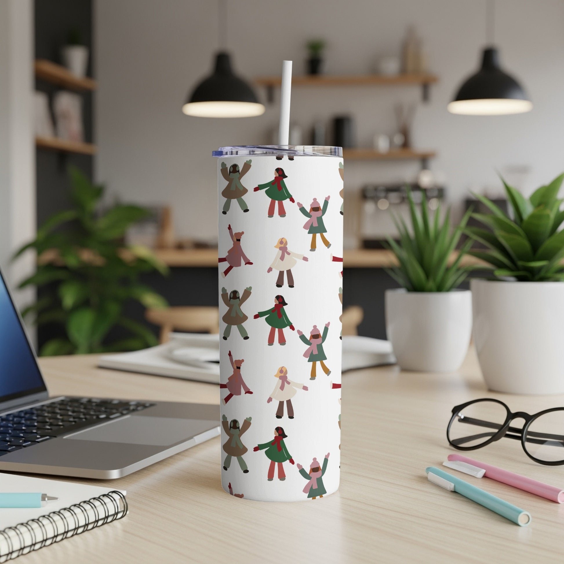 White tumbler with repeating pattern of diverse stick figures wearing colorful winter coats.