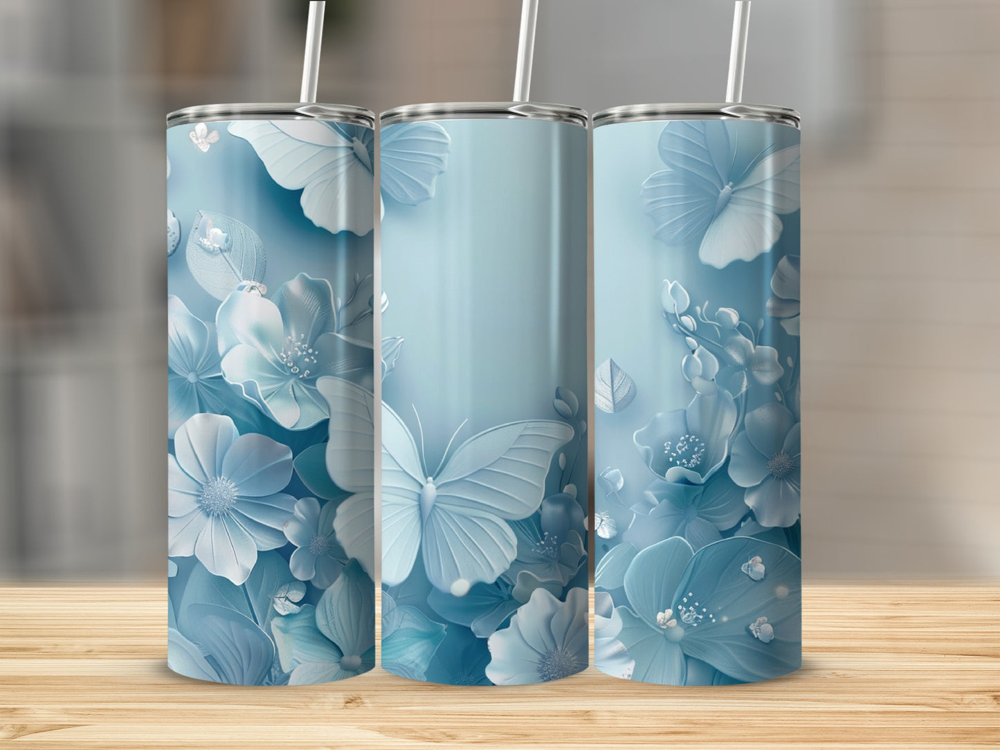Three pastel blue tumblers with butterfly and floral designs.
