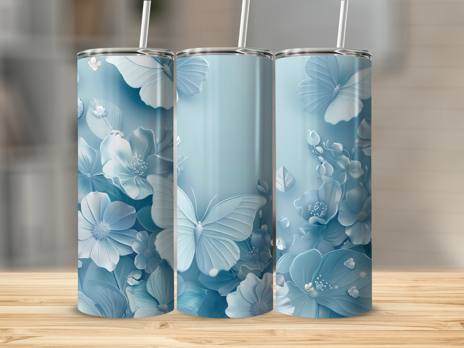 Three pastel blue tumblers with butterfly and floral designs.