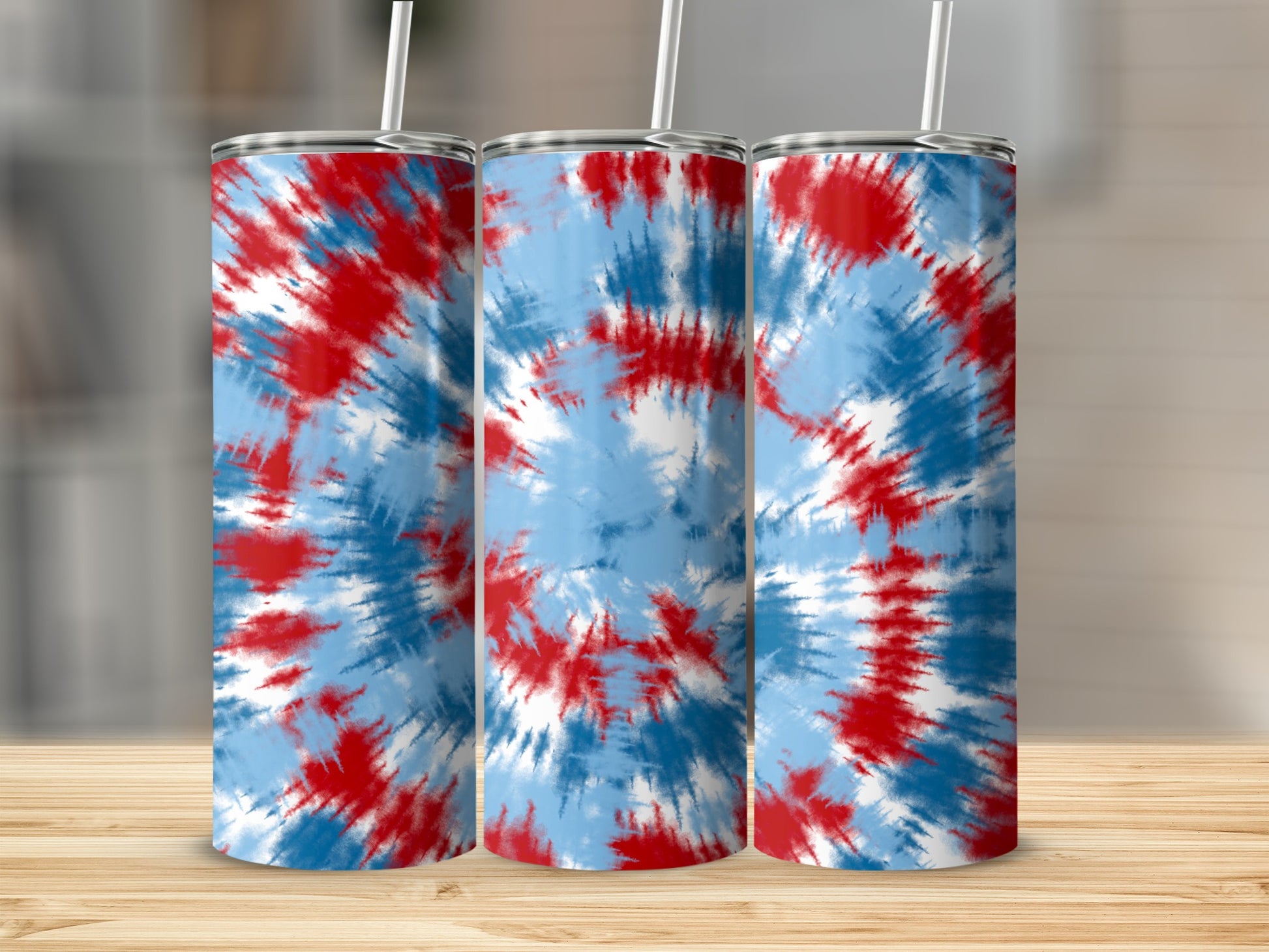 Three tumblers with red, white, and blue tie-dye patterns stand on a wooden surface.