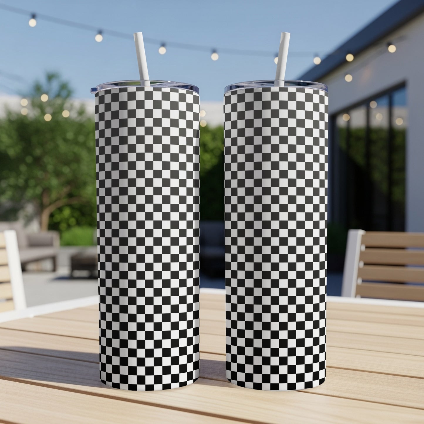 Two tumblers with black and white checkerboard pattern on a wooden table.