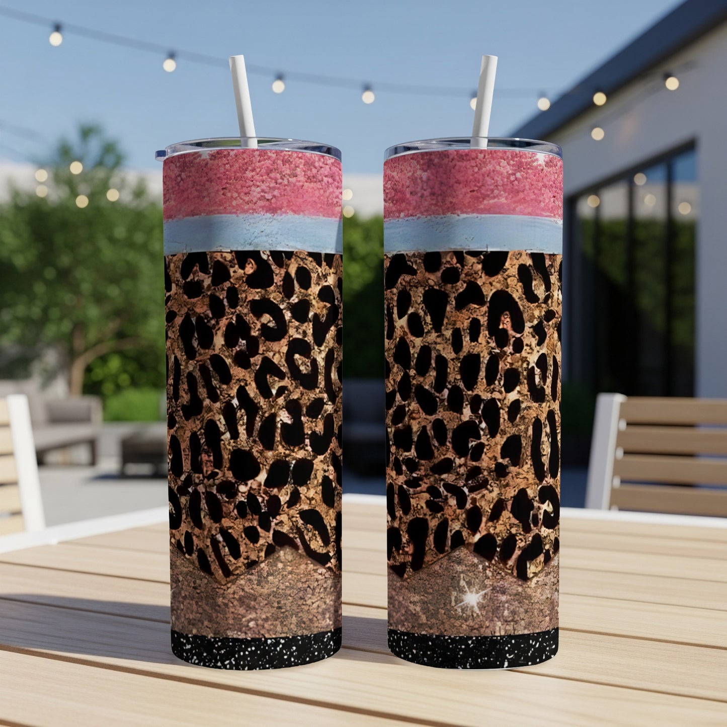 Two skinny tumblers with leopard print, glitter, and pink and blue bands.