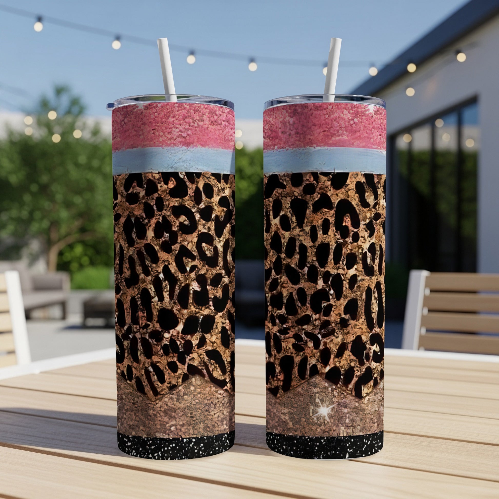 Two skinny tumblers with leopard print, glitter, and pink and blue bands.