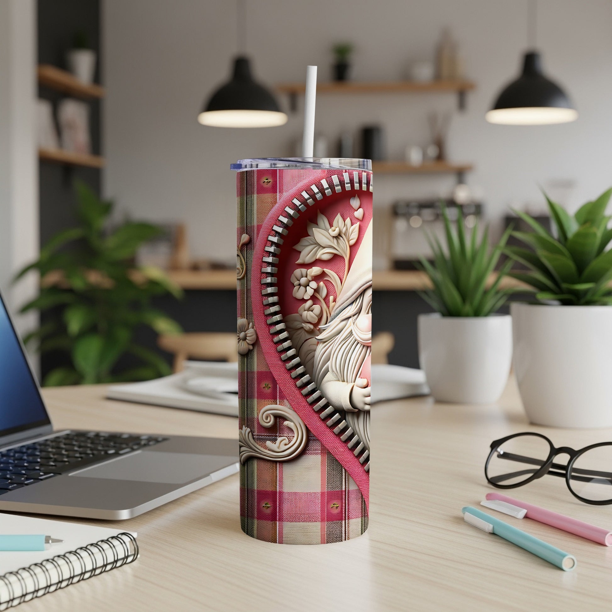 Pink plaid tumbler with gnome design and white straw on desk.