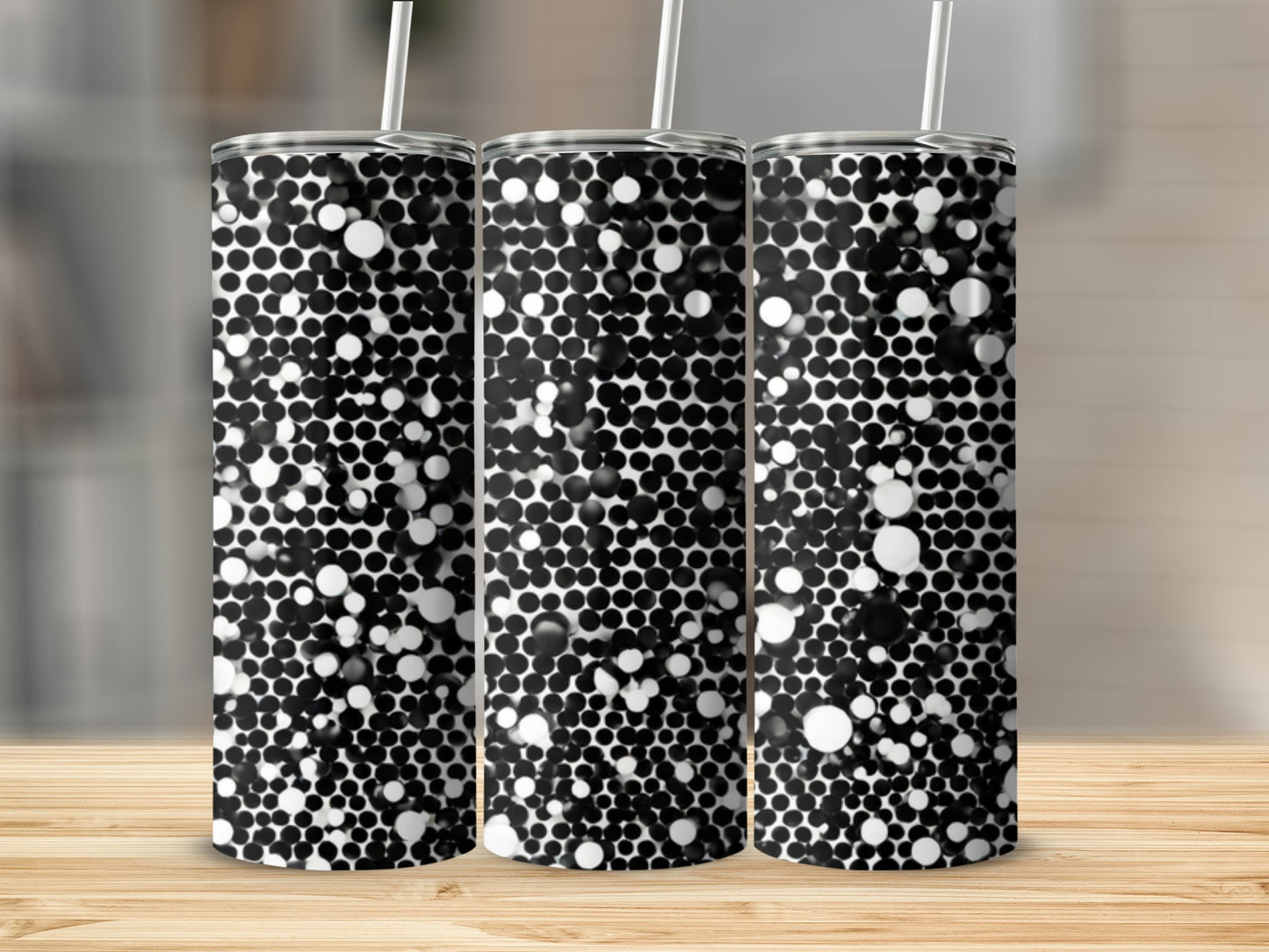 Three tumblers with a black and white polka dot pattern on a wooden surface.