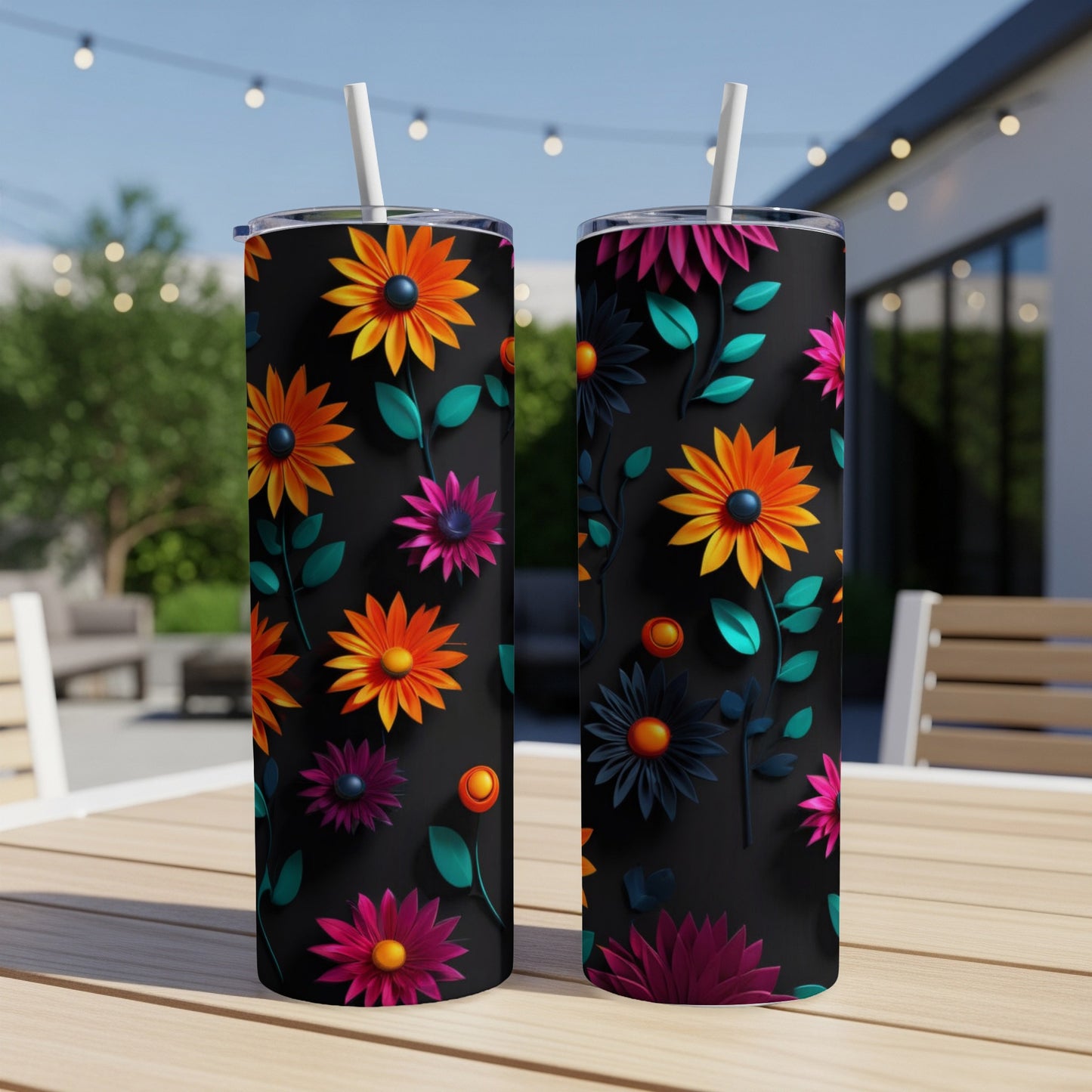 Two tall, black tumblers with a colorful floral pattern sit on a wooden table.