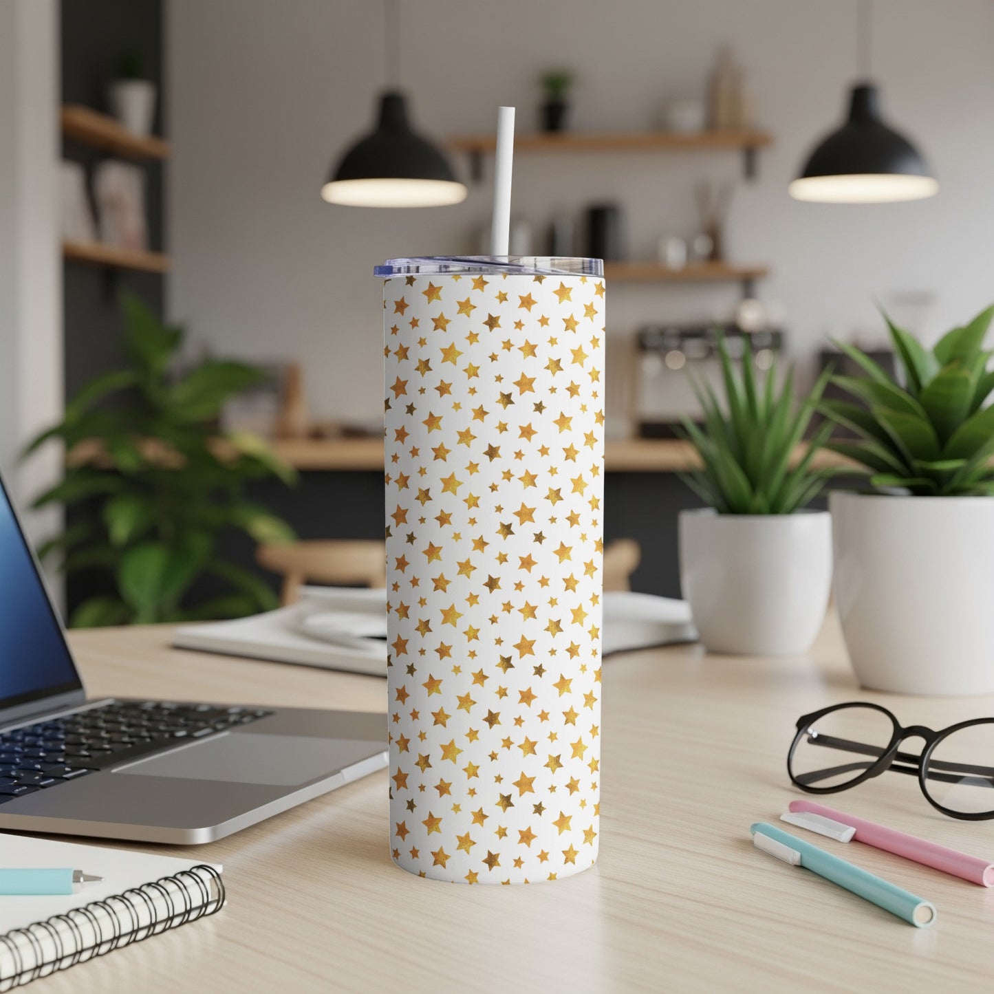 White tumbler with overlapping gold foil stars and a white straw.