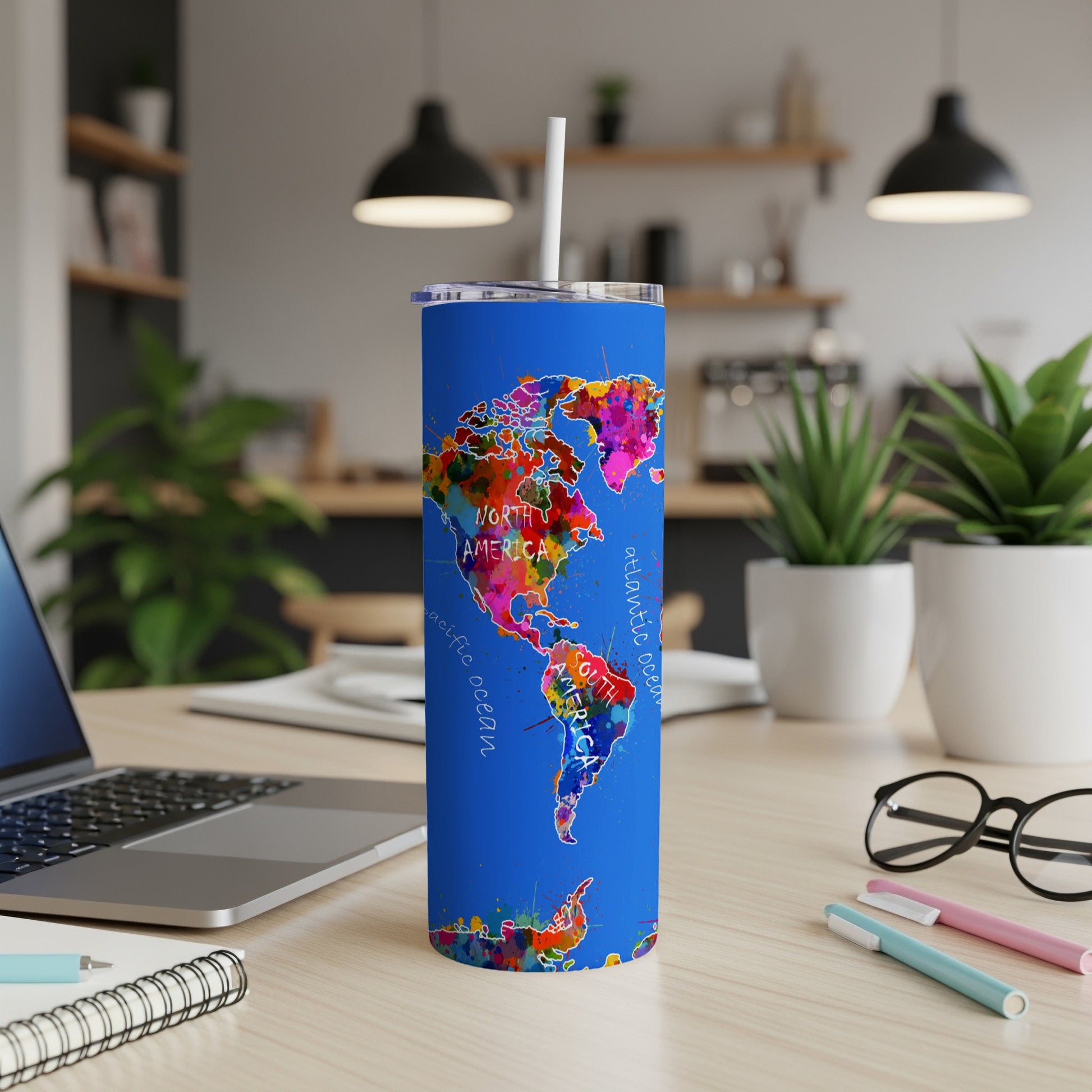 Blue tumbler with colorful watercolor world map design, including North and South America.