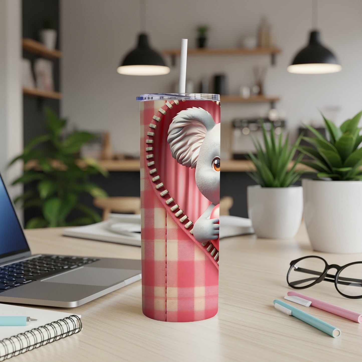 Pink checkered tumbler with a cartoon koala peeking from behind a zipper.