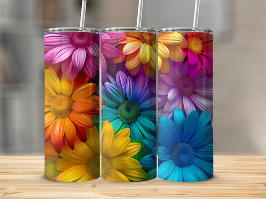 Three colorful floral tumblers with vibrant petals on a wooden surface.