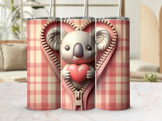 Pink plaid tumbler with zipper revealing a smiling koala holding a heart.