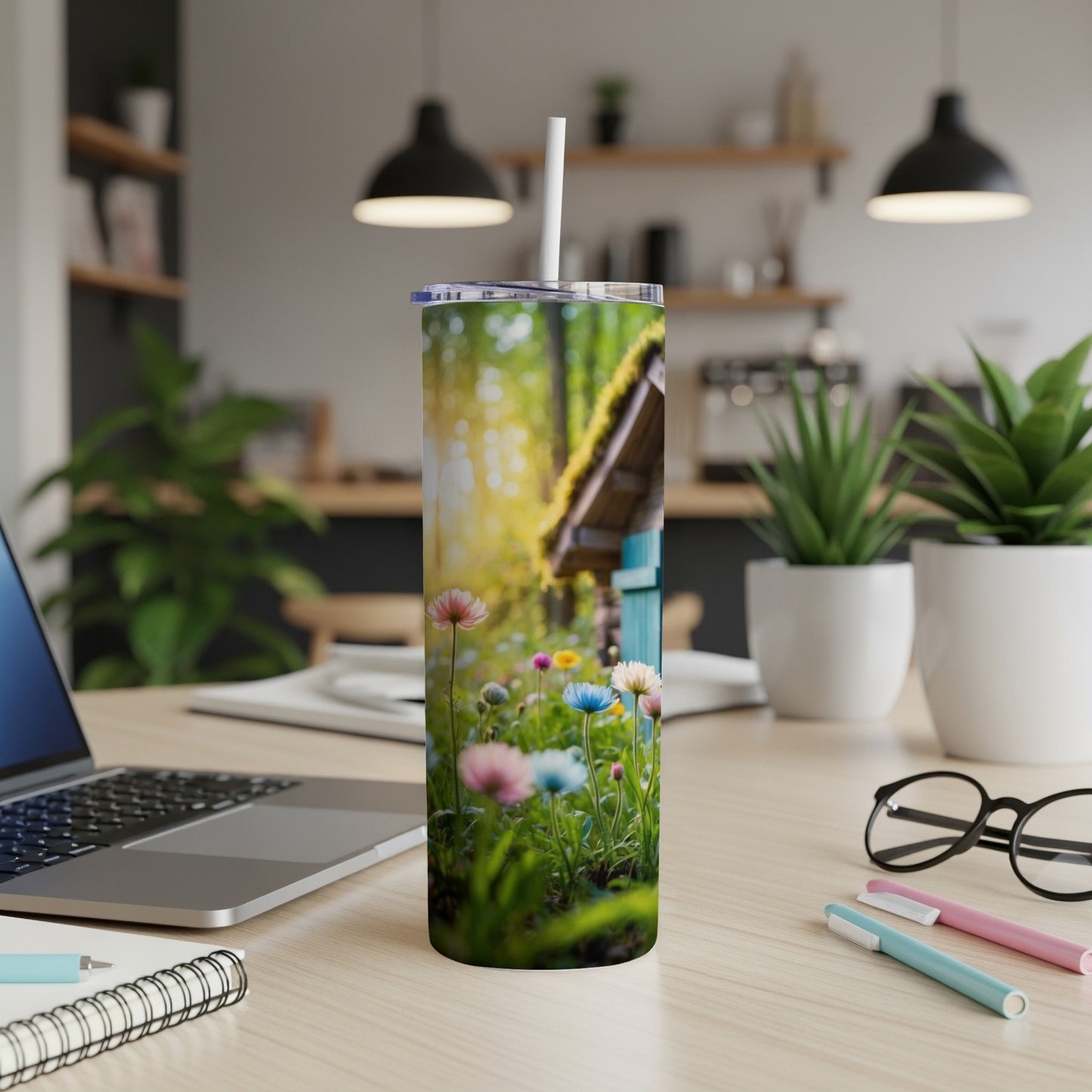 Tumbler with a scene of colorful wildflowers and a small wooden structure.