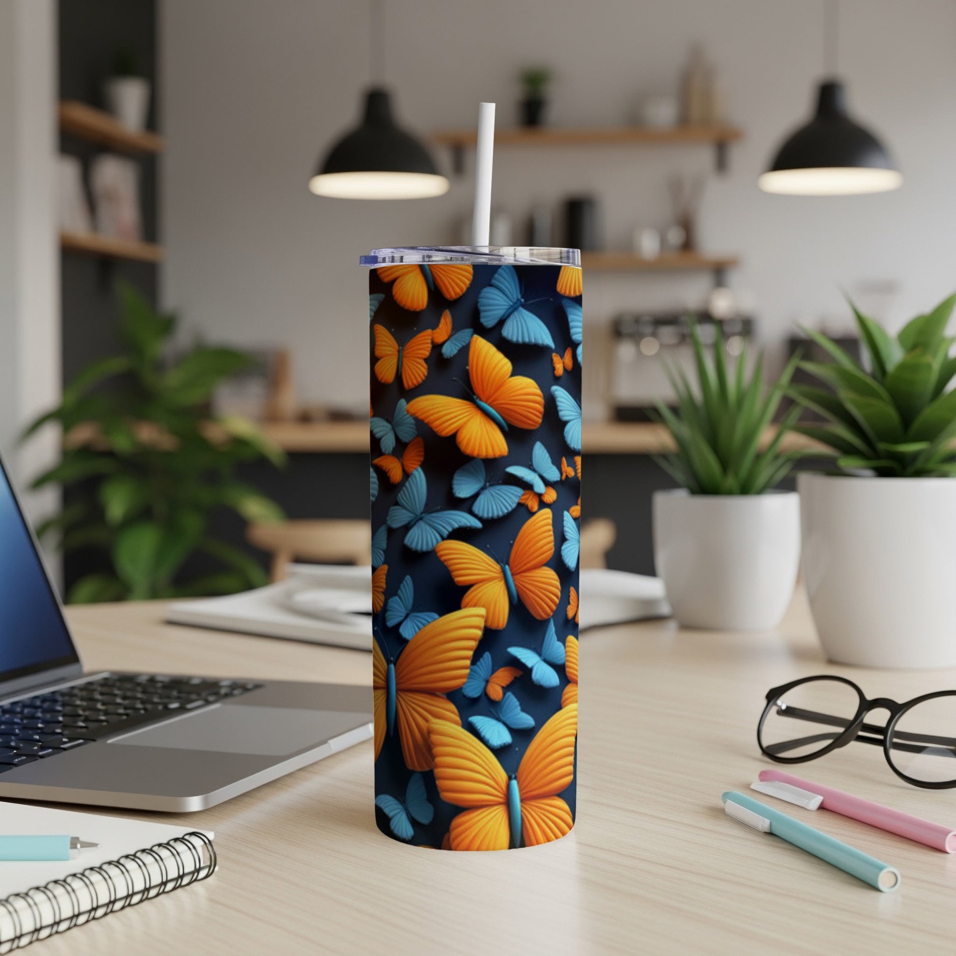 Blue and orange butterflies adorn a black tumbler with a white straw.
