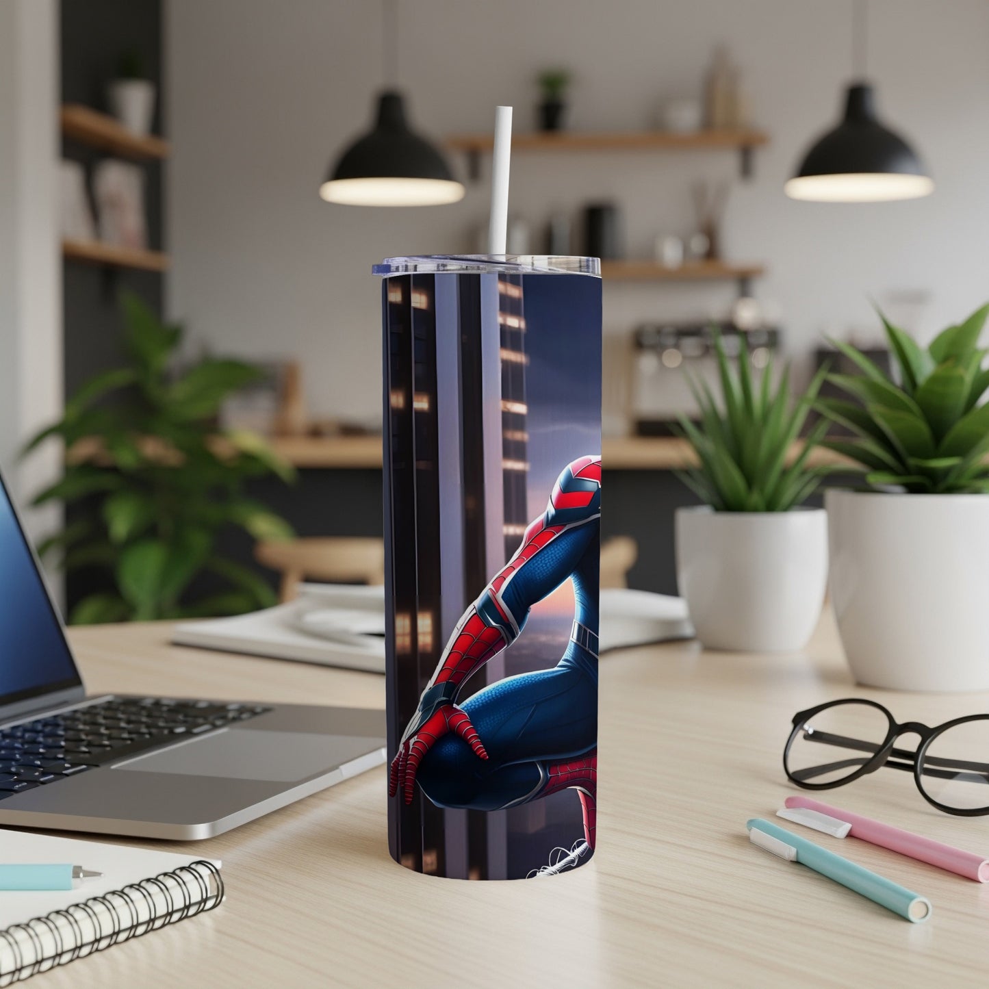 Spiderman character on a tall tumbler with straw, on a desk.